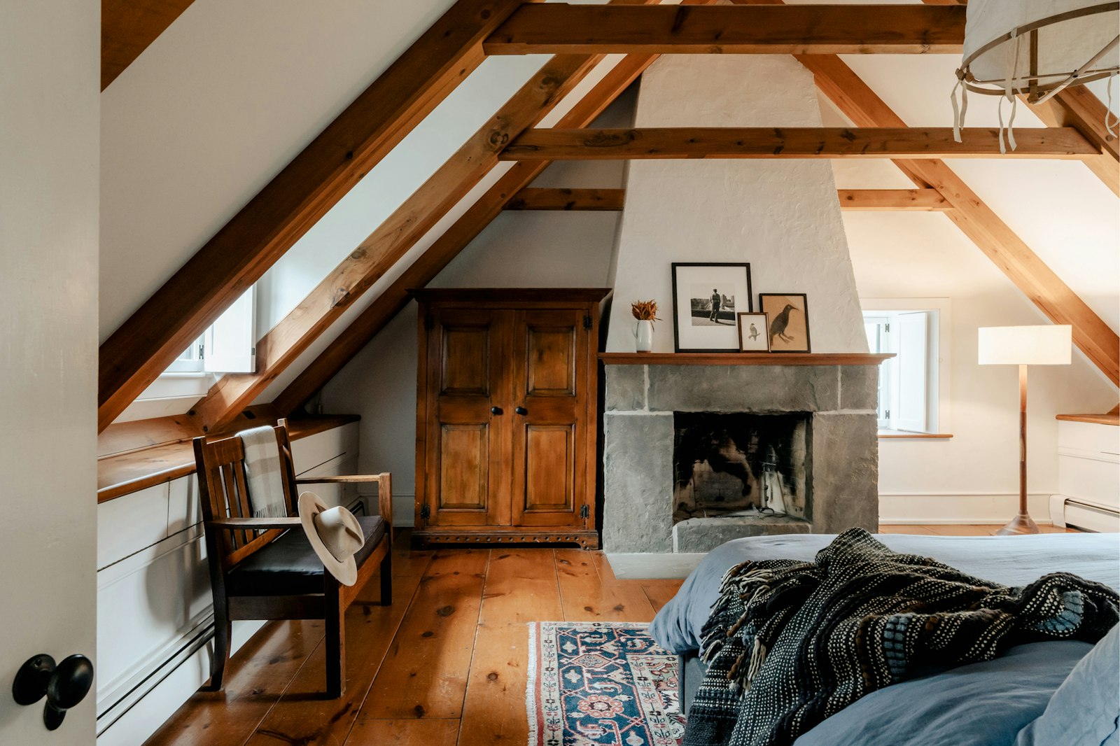 Zimmer unter dem Dach mit Sichtbalken, offenem Kamin und Dielenboden