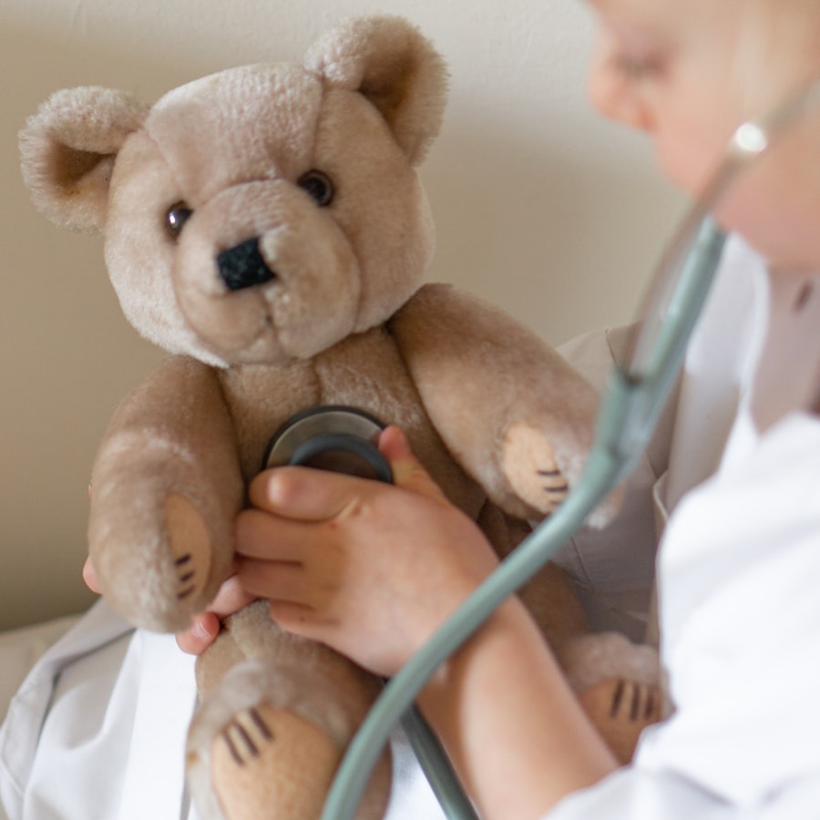 Kind hört mit einem Stethoskop den Teddybären ab