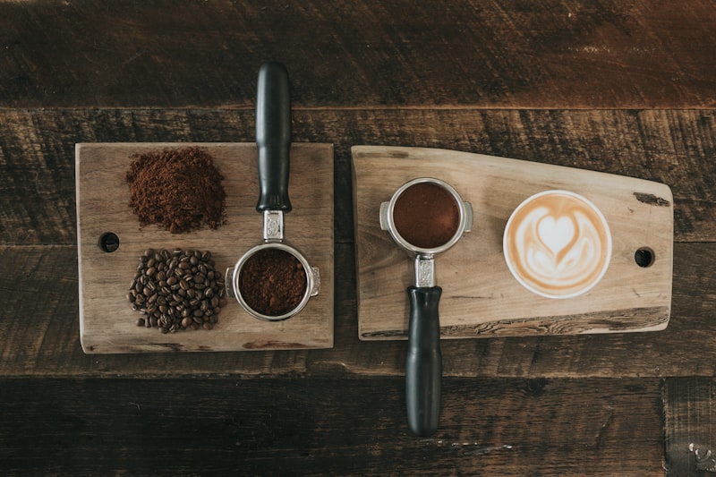 Frisch gemahlener Kaffee und Latte Art auf einem Holzbrett