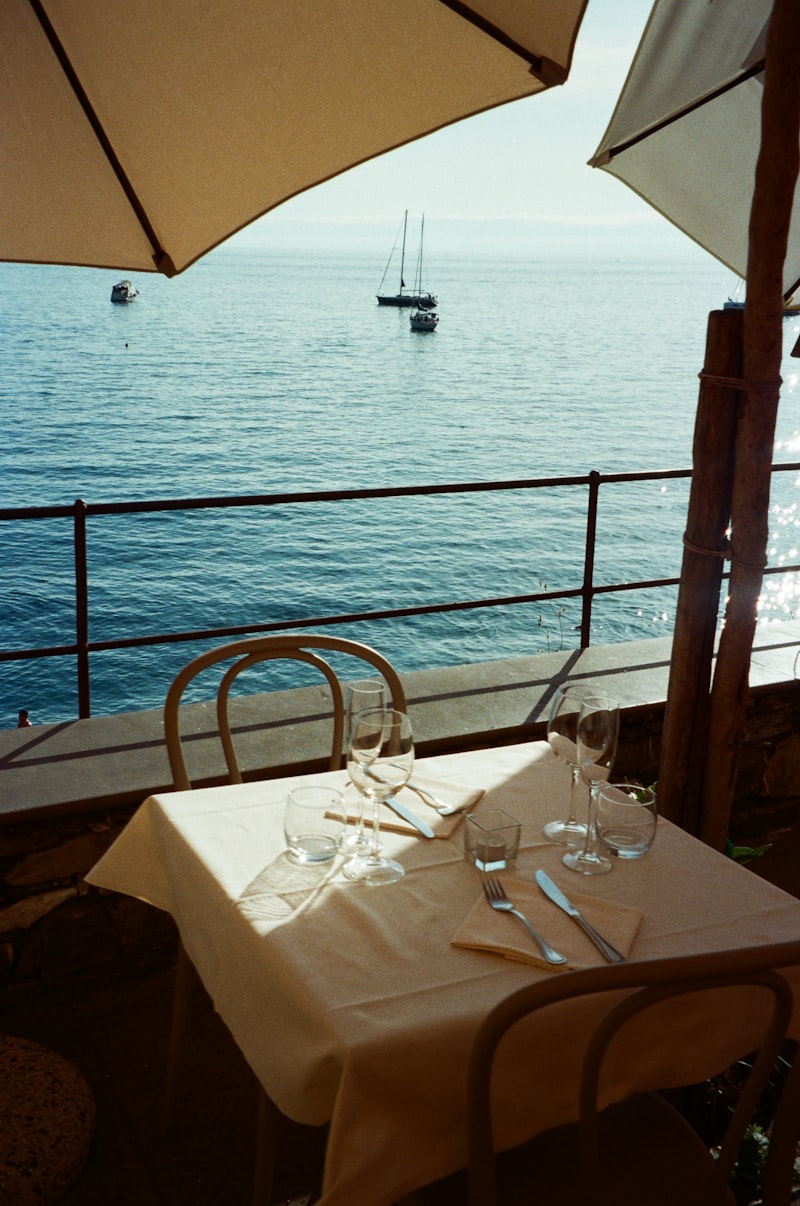 Gedeckter Tisch auf einer Terrasse mit Blick aufs Meer