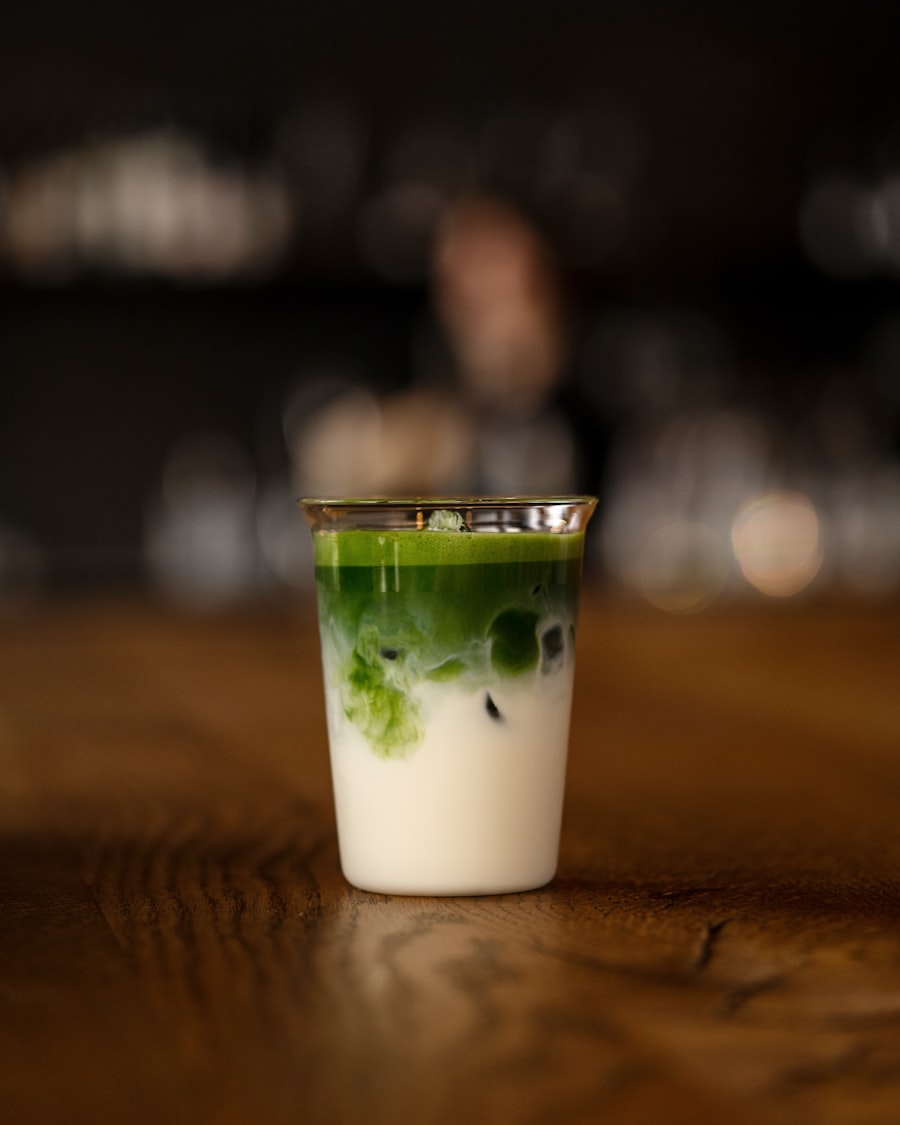 Glas mit eisgekühltem Matcha Latte, die grüne Schicht läuft in die weiße Hafermilch